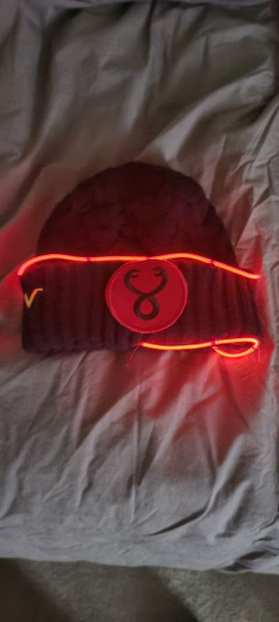 An old cap with a glowing electroluminescent wire patch sewn on